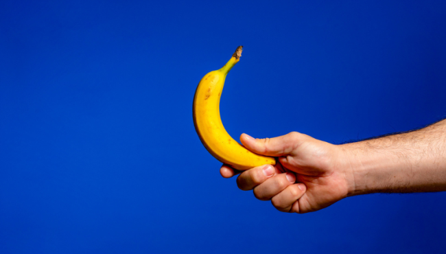 Man holding banana – how to straighten your penis